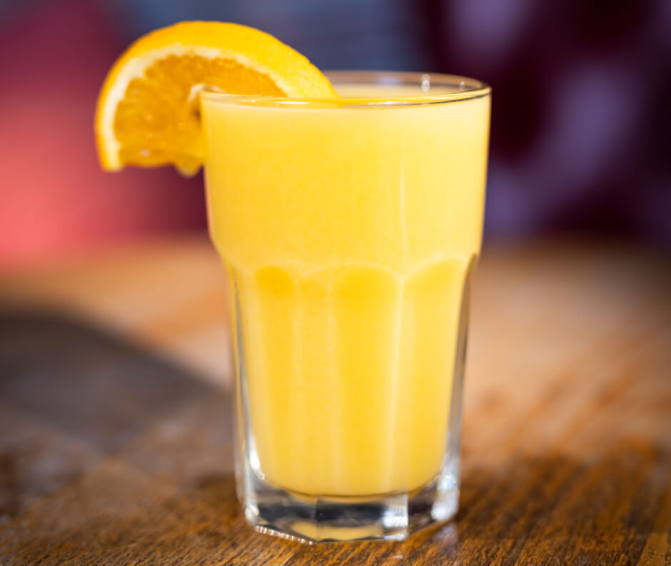 image of orange juice in a glass on a table