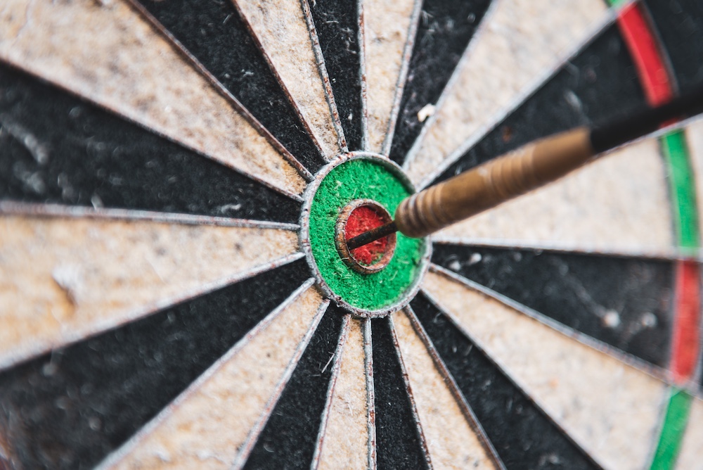 Image of a darts board with the dart in the bullseye